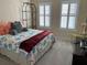 Bright bedroom with a queen bed, window shutters and a shelving unit at 3638 Trafalgar Way # 102, Palm Harbor, FL 34685