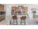 Granite kitchen island with seating and modern pendant lighting at 3994 Medicci Ln, Wesley Chapel, FL 33543