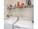 Bright laundry area featuring modern washer and dryer units and shelf for storing detergents and ironing accessories at 4221 W Spruce St # 2418, Tampa, FL 33607