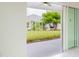 View of backyard through sliding glass doors, showcasing a grassy area and patio at 479 Winwood Ct, Port Charlotte, FL 33954