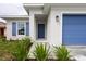 Front entry and blue garage door of a one-story home at 479 Winwood Ct, Port Charlotte, FL 33954