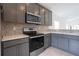 Modern kitchen with gray cabinets and stainless steel appliances at 479 Winwood Ct, Port Charlotte, FL 33954