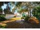 Landscaped backyard with large trees and a stone path at 55 Edgewater Dr, Dunedin, FL 34698