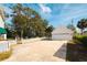 Spacious driveway with attached two-car garage and white picket fence at 55 Edgewater Dr, Dunedin, FL 34698