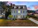 Two-story white house with black shutters, charming front porch, and manicured lawn at 55 Edgewater Dr, Dunedin, FL 34698