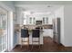 Modern kitchen with white cabinets, stainless steel appliances, and breakfast bar at 55 Edgewater Dr, Dunedin, FL 34698