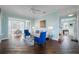 Open living space with hardwood floors, blue chairs, and a view into dining area at 55 Edgewater Dr, Dunedin, FL 34698