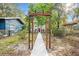Wooden arbor frames the walkway to the charming home with a red door at 807 E Genesee St # 1/2, Tampa, FL 33603