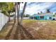 Large backyard with a teal house and palm trees at 815 Lantana Ave, Clearwater Beach, FL 33767