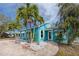 Quaint teal home with palm trees and a brick driveway at 815 Lantana Ave, Clearwater Beach, FL 33767