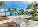 Charming light blue home with palm trees and a brick driveway at 815 Lantana Ave, Clearwater Beach, FL 33767