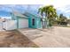 A teal house with a white garage door and palm trees in the front yard at 815 Lantana Ave, Clearwater Beach, FL 33767