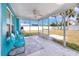 Relaxing screened porch with teal chairs and ceiling fan at 815 Lantana Ave, Clearwater Beach, FL 33767
