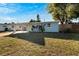 Charming light blue house with a yellow door, carport, and spacious lawn at 11950 105Th N Ln, Largo, FL 33773