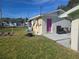 Backyard view of house with additional building and grass at 128 18Th Nw St, Ruskin, FL 33570