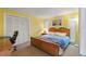 Bedroom with a wooden bed frame and yellow walls at 1998 Massachusetts Ne Ave, St Petersburg, FL 33703