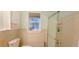Bathroom featuring a shower with glass doors, toilet, and window providing natural light in the space at 2800 47Th S St, Gulfport, FL 33711