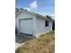 Exterior shot of a one-car garage with white siding and a traditional roll-up door at 2800 47Th S St, Gulfport, FL 33711