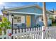 Charming light blue house with a yellow door, white picket fence, and landscaped yard at 3007 56Th S St, Gulfport, FL 33707