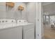 Upper-level laundry room with washer, dryer, and shelving at 31471 Woodland Race Loop, Wesley Chapel, FL 33545