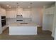 Bright kitchen with modern white cabinets, stainless steel appliances, and a large center island at 633 Allora Ave, Nokomis, FL 34275