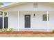 Front porch with red mulch landscaping and black front door at 8407 N Orangeview Ave, Tampa, FL 33617