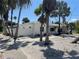 Charming single-story home surrounded by lush palm trees and a fenced yard at 909 Mandalay Ave, Clearwater Beach, FL 33767