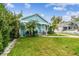 Light blue house with walkway, palm trees, and green lawn at 1153 Drew St, Clearwater, FL 33755