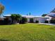 Front view of a ranch style home with a white exterior, blue garage door, and lush lawn at 117 Baywood Ave, Clearwater, FL 33765