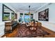 Bright dining room with large windows offering water views, complemented by elegant decor and modern art at 118 Harbor View Ln, Belleair Bluffs, FL 33770