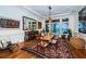 Bright dining room with water views, features a long wooden table, stylish rug, and unique artwork at 118 Harbor View Ln, Belleair Bluffs, FL 33770