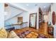 Bright hallway with beautiful staircase, hardwood floors, built-in bookshelves and large mirror at 118 Harbor View Ln, Belleair Bluffs, FL 33770
