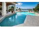 Luxury pool with waterfront views, lounge chairs, and covered patio, perfect for outdoor relaxation and entertaining at 118 Harbor View Ln, Belleair Bluffs, FL 33770