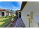 Brick-paved walkway leading to the property's entrance, alongside landscaping at 12115 Amica Loop, Venice, FL 34293