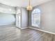 Open dining room with wood-look floors, multiple archways and a chandelier at 1252 Highwood Pl, Wesley Chapel, FL 33543