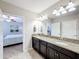 Bathroom with double vanity, granite countertop and a view into the bedroom at 16847 Whisper Elm St, Wimauma, FL 33598
