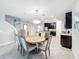 Open dining room with a round wooden table and six beige chairs at 16847 Whisper Elm St, Wimauma, FL 33598