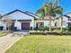 Two-story home with dark brown double garage doors and landscaped lawn at 16847 Whisper Elm St, Wimauma, FL 33598