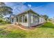 House exterior with sunroom and manicured lawn at 2283 Whisper Walk Dr, Spring Hill, FL 34606