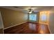 A naturally lit living room with beautiful hardwood flooring, ceiling fan, and entrance to foyer at 37670 Aaralyn Rd, Zephyrhills, FL 33542