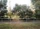 Backyard view with trees and a fence at 37715 Aaralyn Rd, Zephyrhills, FL 33542