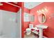 Bathroom with a shower, toilet, pedestal sink, and colorful red walls for a vibrant aesthetic at 408 E Amelia Ave, Tampa, FL 33602