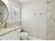 This bathroom features a marble countertop, a round mirror, and a tiled shower with a glass door at 5004 W Leona St, Tampa, FL 33629