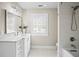 Bright bathroom features a white vanity with stone countertops and a separate tiled shower area at 5004 W Leona St, Tampa, FL 33629