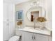 Modern bathroom with a vanity, round mirror, decorative vases and framed wall art at 5004 W Leona St, Tampa, FL 33629