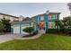 Charming teal two-story home with a red door and landscaped yard at 5004 W Leona St, Tampa, FL 33629