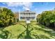 Charming two-story home with double porches, white railings, and lush landscaping in a tropical setting at 5004 W Leona St, Tampa, FL 33629