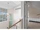 Hallway with hardwood railing and stairs leads to an open bedroom at 5004 W Leona St, Tampa, FL 33629