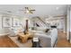 Bright living room featuring a staircase, hardwood floors, and an open-concept design connected to the kitchen at 5004 W Leona St, Tampa, FL 33629