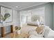 Open concept main bedroom and sitting area with neutral tones, light hardwood floors, and stylish decor at 5004 W Leona St, Tampa, FL 33629